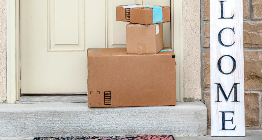 Packages on the doorstep of a home with a welcome sign in Kansas City